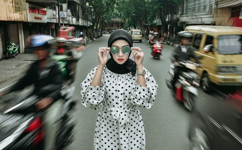 Blurred motion of woman on road in city