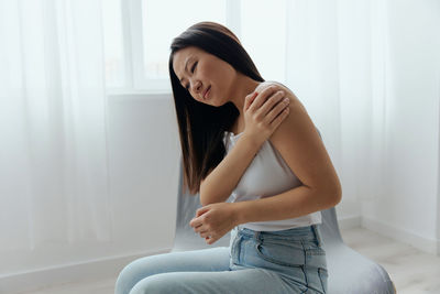 Side view of young woman exercising at home