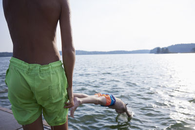 Teenage boy jumping into water