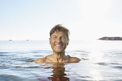 Portrait of happy man bathing in the sea