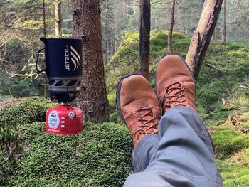 Low section of man relaxing in forest
