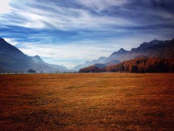 Scenic view of field and mountains against sky