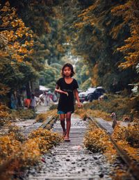 Full length of woman standing on autumn leaves