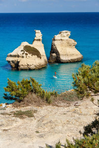 Rock formations in sea against blue sky