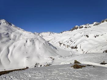 Scenic view of snowcapped mountains against clear blue sky