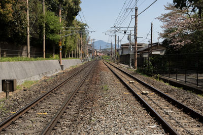 Railroad tracks amidst electricity pylons