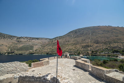 Scenic view of lake and mountains against clear blue sky