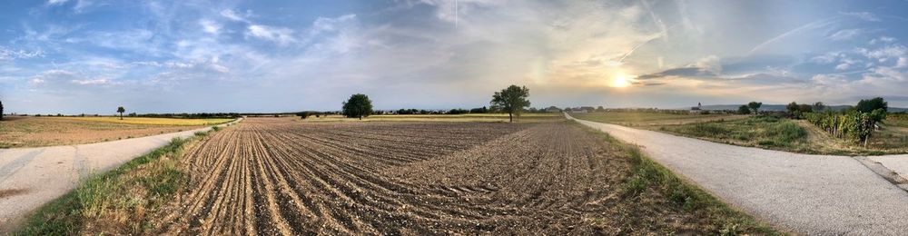 Panoramic shot of agricultural field against sky