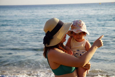 Side view of woman wearing hat at beach