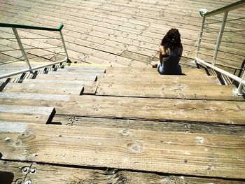 High angle view of woman sitting on bench