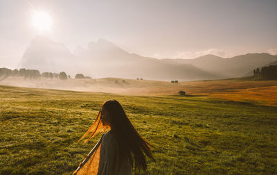 Rear view of woman on field against sky