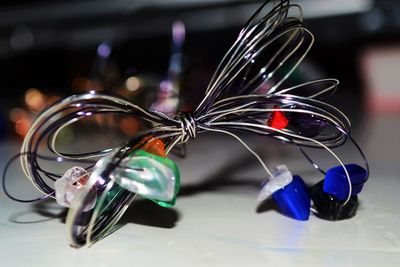 Close-up of tied metallic wire with small stones on table