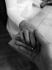 Midsection of couple holding hands on table