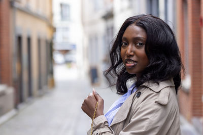 Young woman looking away while standing in city