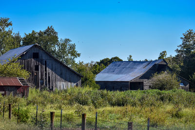 House on field against clear blue sky