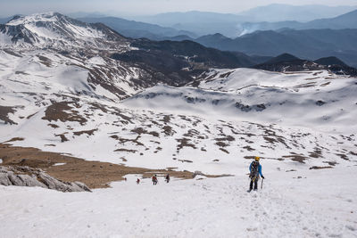 Hiker standing on snowcapped mountain