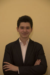 Portrait of young man standing against wall