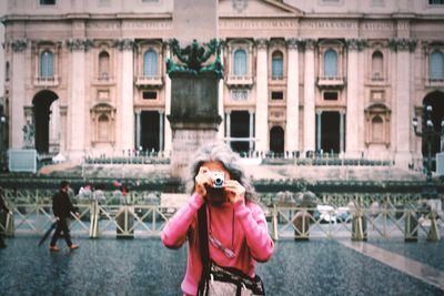 Young woman standing in front of building