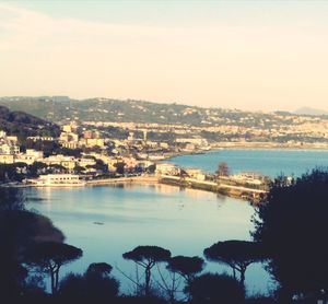 Scenic view of lake by city against sky