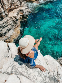 High angle view of woman sitting on rock