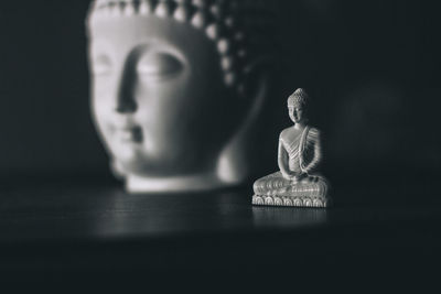 Close-up of buddha statue against black background