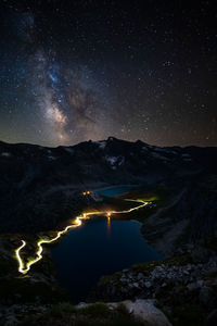 Scenic view of illuminated mountains against sky at night