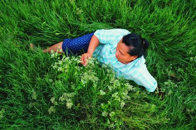 High angle view of woman sitting on grassy field