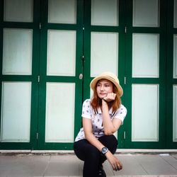 Portrait of smiling young woman sitting against window