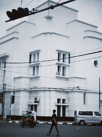 People walking on street by building in city