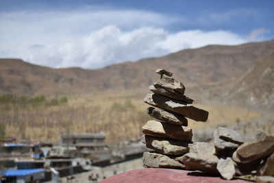 Stack of rocks on mountain against sky