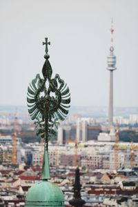 Communications tower in city against clear sky