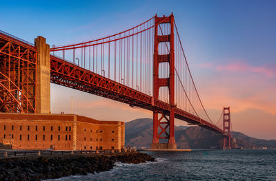 Golden gate bridge over bay of water during sunset