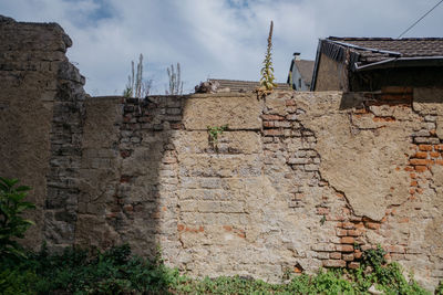 Low angle view of old building against cloudy sky