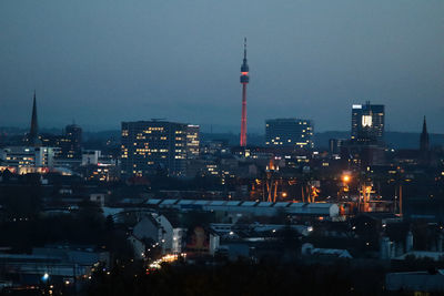 Illuminated buildings in city at dusk