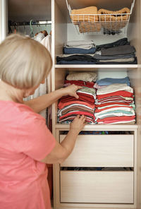 Rear view of senior woman looking at wardrobe