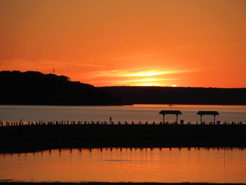 Scenic view of lake against orange sky