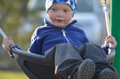 Cute boy sitting on swing