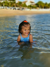 Portrait of cute baby girl swimming in water