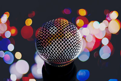Close-up of microphone against illuminated lighting