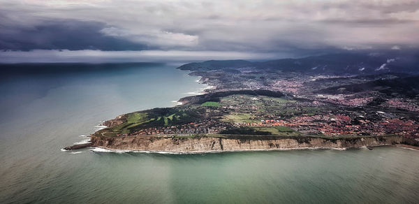 High angle view of city by sea against sky