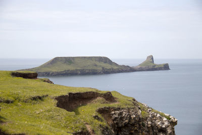 Scenic view of rocks on sea against sky