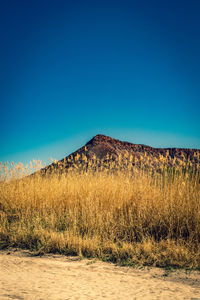 Scenic view of land against clear blue sky