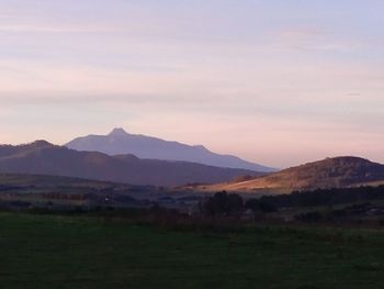 Scenic view of field and mountains against sky