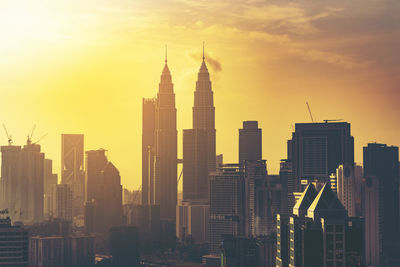 Petronas towers against sky during sunset