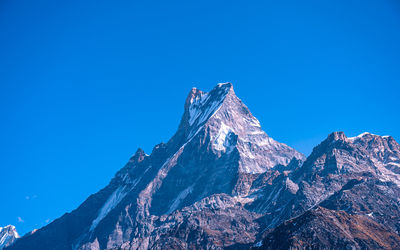 Low angle view of mountain against clear blue sky