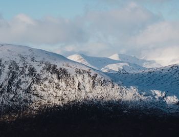 Scenic view of mountains against cloudy sky
