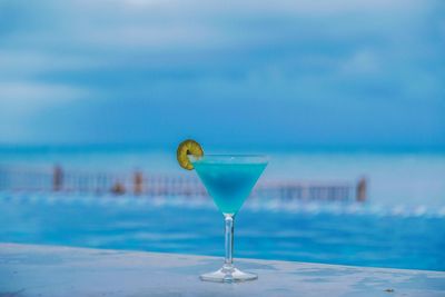 Cocktail against infinity pool and sea