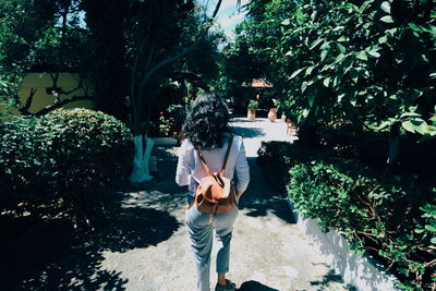 Rear view of woman standing by plants