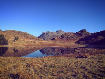 Scenic view of mountains against clear blue sky