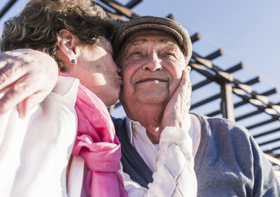 Portrait of happy senior man kissed by his wife